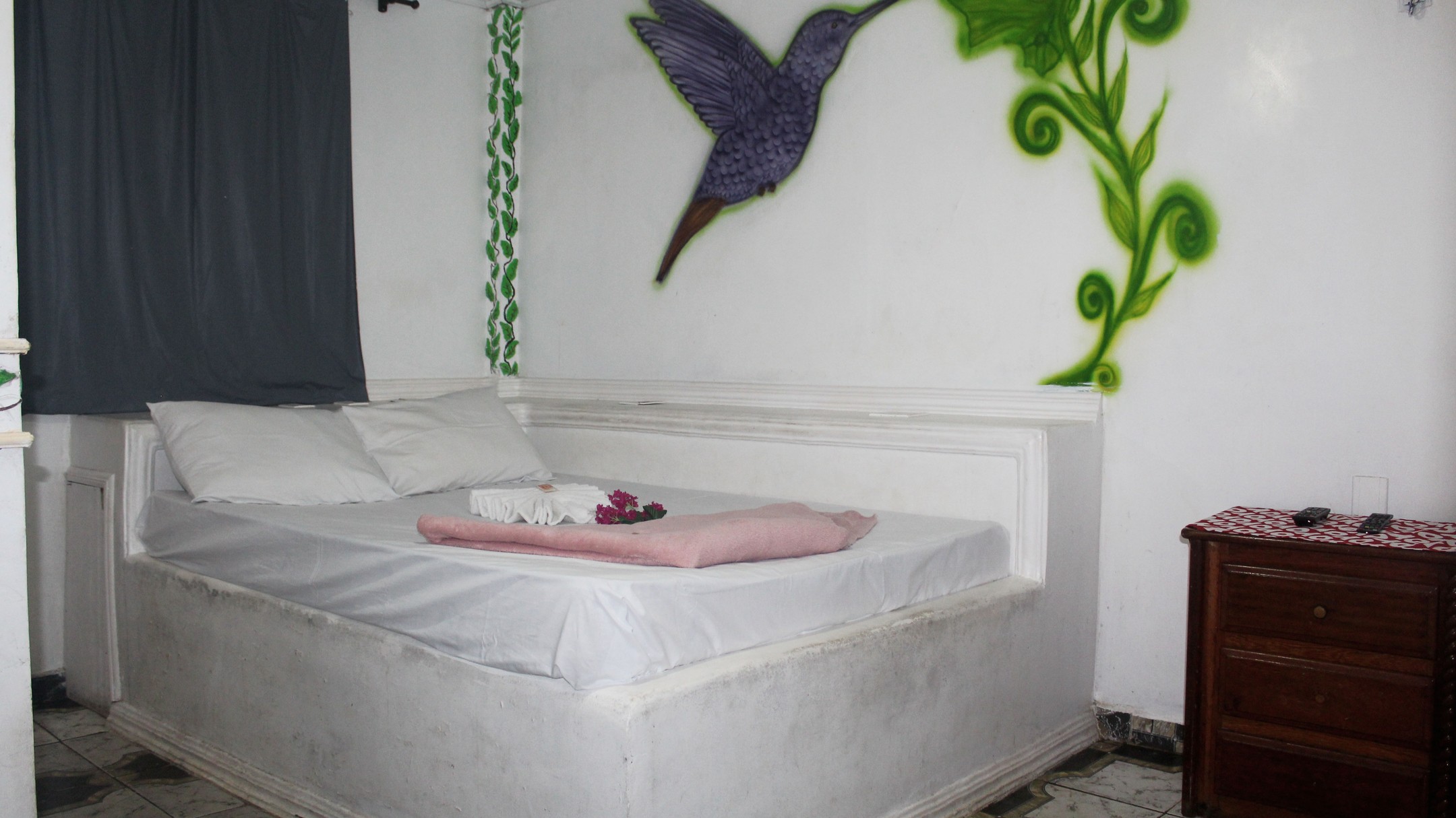 Quarto Beija-Flor com mural de beija-flor e criado-mudo