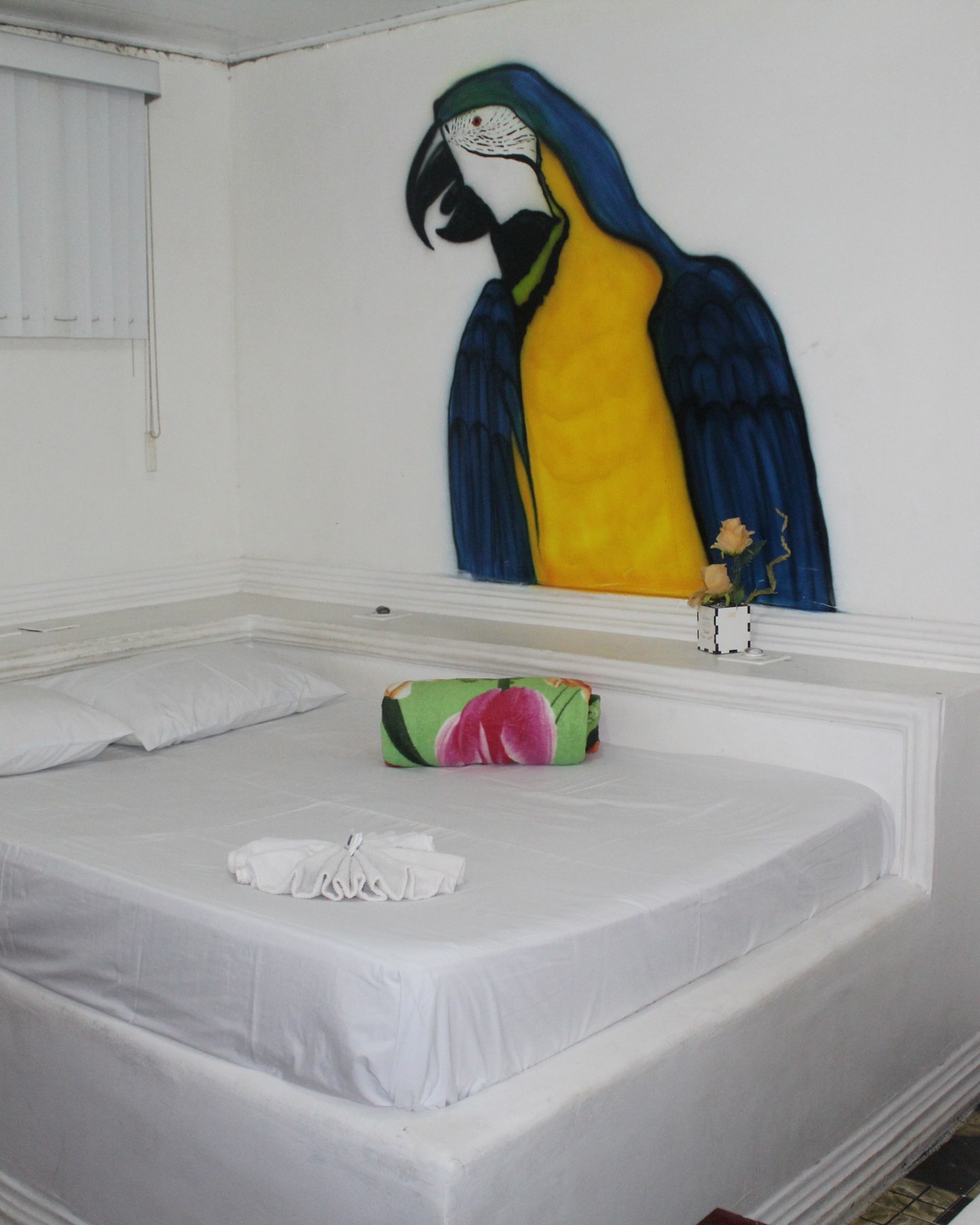 Quarto Arara com mural de arara azul e amarela