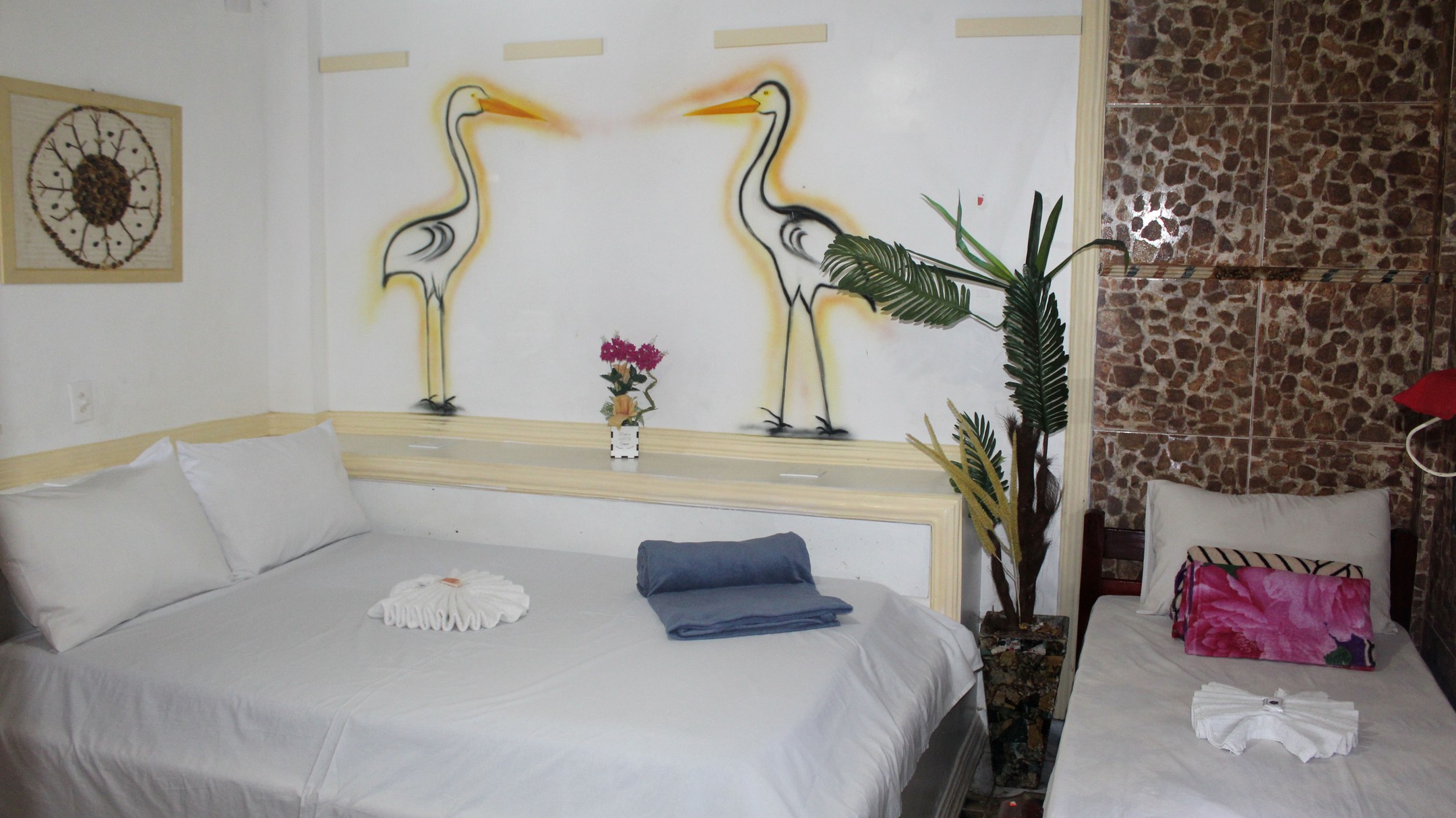 Quarto Garças com duas camas e mural de garças, ideal para família